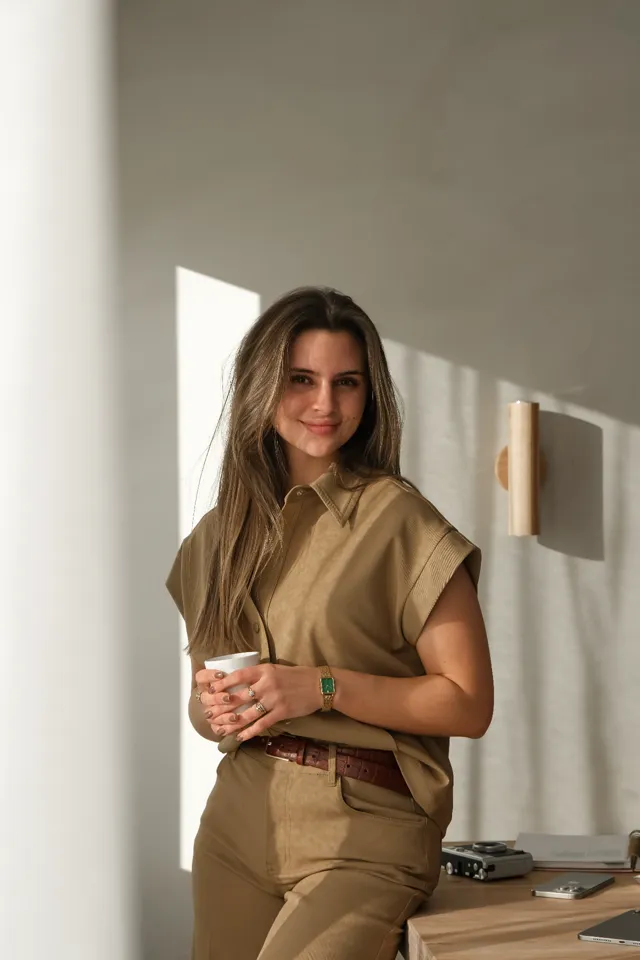 Roos Kuijstermans, Meta Ads strateeg, leunend tegen haar bureau met een kop koffie